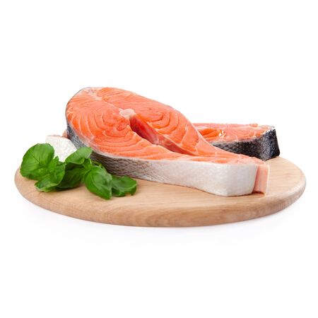 Salmon steak red fish decorated with basil on the kitchen boardの写真素材