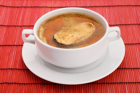 Soup with salmon and hot peppers on a red backgroundの写真素材