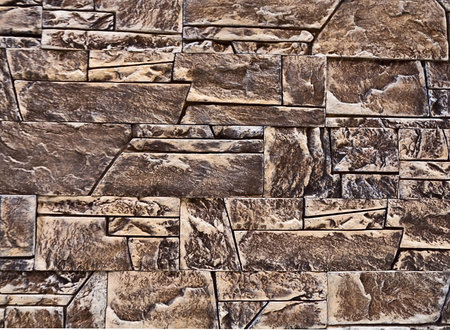 A wall of various shapes stone bricks as backgroundの写真素材