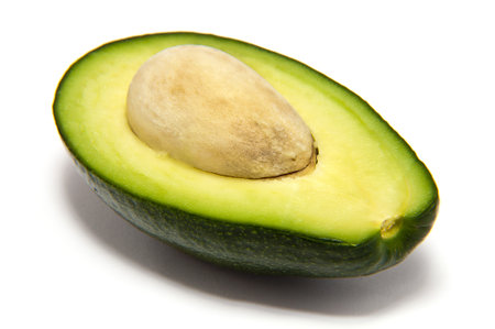 half avocado with stone on a white backgroundの写真素材