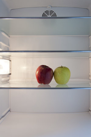 two apples on a shelf in the refrigeratorの写真素材