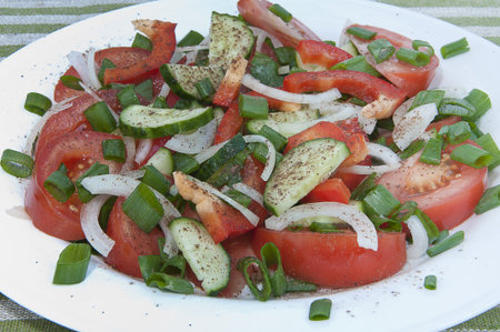 Fresh mixed vegetable salad on a white plateの写真素材