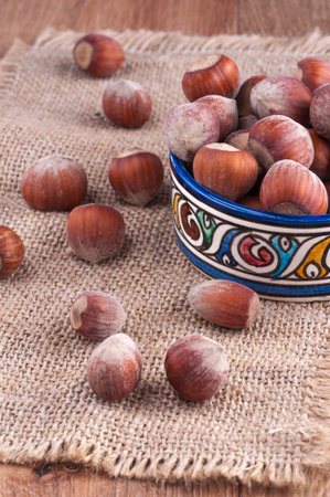 Hazelnuts on a table In a colored bowlの写真素材