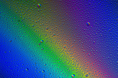 water drops on blue green yellow cyan rainbow gradient backgroundの写真素材