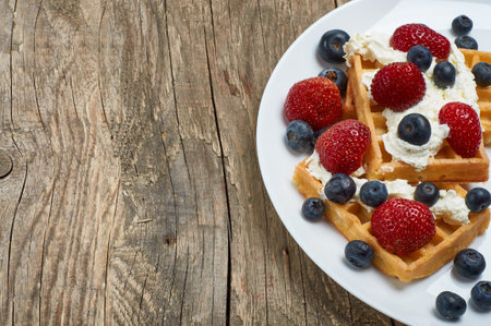 waffles with whipped cream and strawberries and blueberriesの写真素材