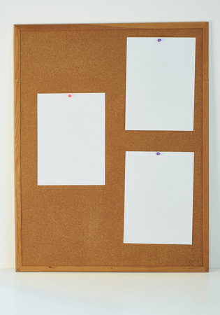 three white sheets of paper pinned on a cork board.の写真素材