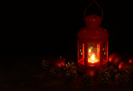 Lantern with burning candle and Christmas decorations on dark background. Space for textの写真素材