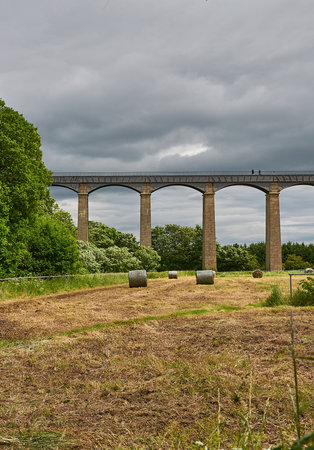 A view of a railway viaduct with hay bales.