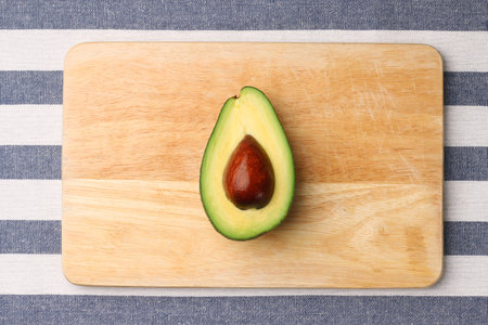 half avocado on wooden and textile background top viewの写真素材