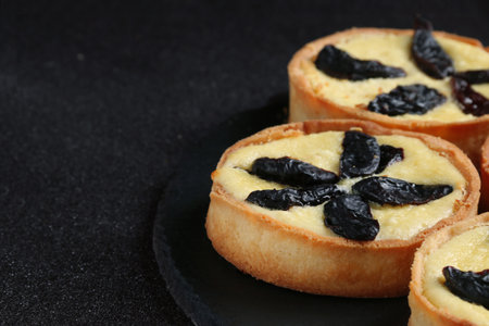 tart with sour cream close up on dark background. cheesecake on slate plate