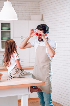 dad and daughter having fun on the kitchen togetherの写真素材