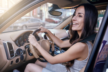 smiling brunette riding car and looking away