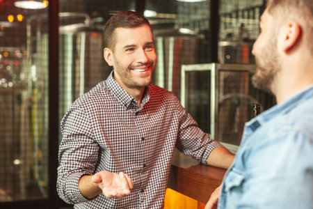 male friends talking together sitting at bar counter