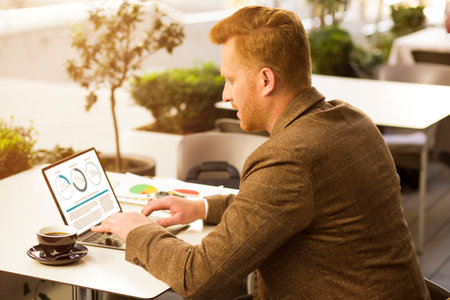 Attentive hardworking director creating statics of his coworkers allocation while having coffee breakの写真素材