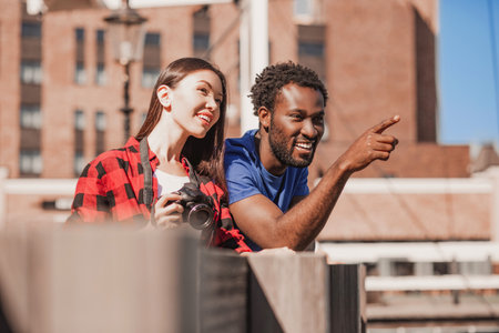 man pointing on something with woman standing at the wooden fence near the riverの写真素材