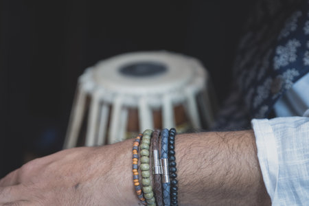 Images of a man's hands (wearing beads) playing the Tabla - Indian classical music percussion...
