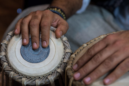 Images of a man's hands (wearing beads) playing the Tabla - Indian classical music percussion...
