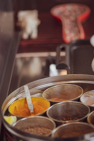 A round container for spices - with ginger and roti - cooking Indian food.の写真素材
