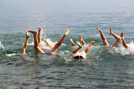 Group of children upside down splashing in the sea.の写真素材