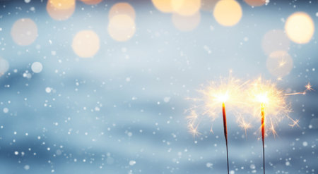 Sparklers lighting up with snow background, light orange and gray, light sky-blueの素材
