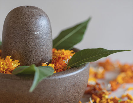 A beautiful still life for the Maha Shivratri festival. A stone Shivling is decorated with marigold flowers and Bilva leaves as a sacred devotional offeringの素材