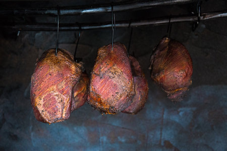 Smoked pork meat in smoker on dark background.の写真素材