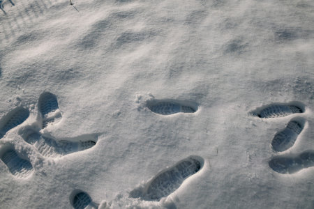 the imprint of the shoes in the fresh snow, it is easy to understand the direction of where the people go with the imprinted silhouette in the snow.の写真素材