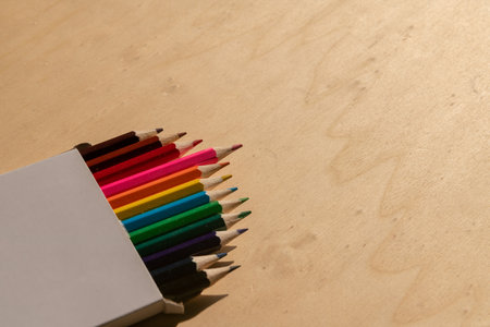 colored pencils: vibrant assortment neatly arranged on a wooden table, ready to unleash creativity with their range of vibrant colours.の写真素材