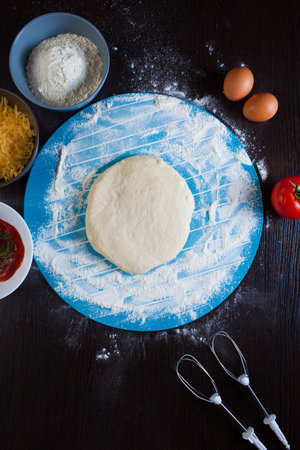 Pizza cooking ingredients. Raw pizza ingredients - dough, sauce, cheese, tomato, flour, eggs.の写真素材