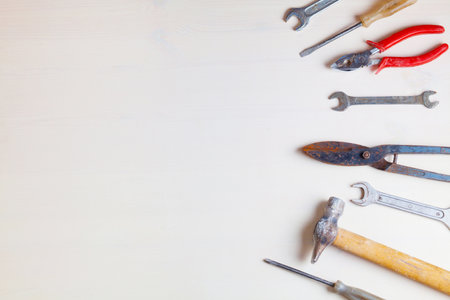 Old working tools on wooden white background. Top view.