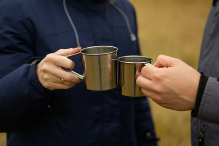 Two travelers in nature drinking coffee in matea mugs.の写真素材