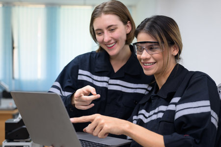 Happy female engineers team using laptop checking and operating