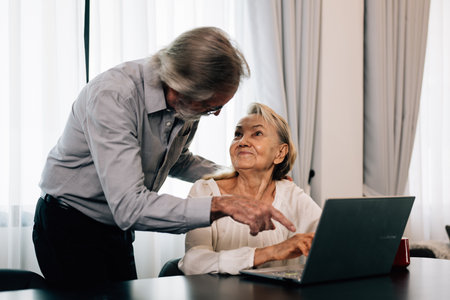 Healthy grandfather and grandmother using laptop for entertainment and shopping