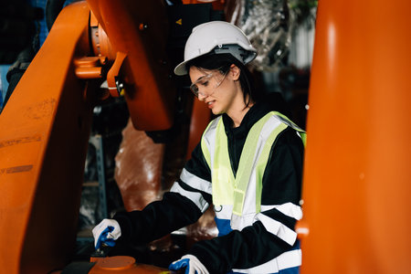 Confident female technician engineer worker checking and inspecting machine