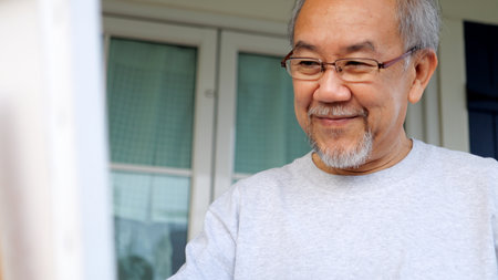 Senior holding color paint drawing on white paperの写真素材