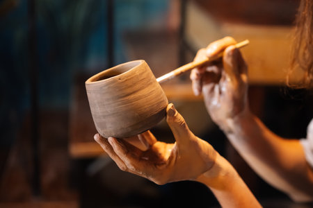 Craftsman potter making jug of clay on the potters wheel circle in workshopの写真素材