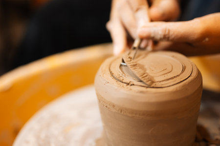 Close up on skillful hands sculpting pottery jar on potter wheelの写真素材