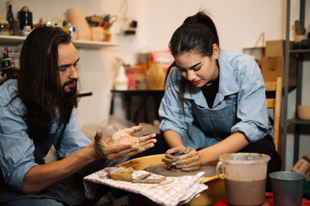 Craftsman potter making jug of clay on the potters wheel circle in workshopの写真素材