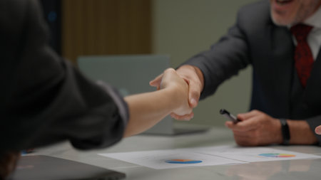 Businessmen shacking hands together showing successful contract agreementの写真素材