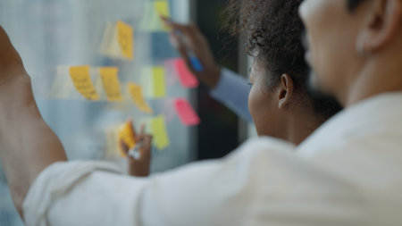 Business people taking reminder post-it notes on board during conferenceの写真素材