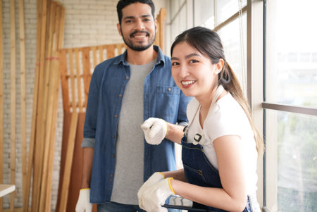 Portrait of happy carpenters designing and planing wood products in workshopの写真素材