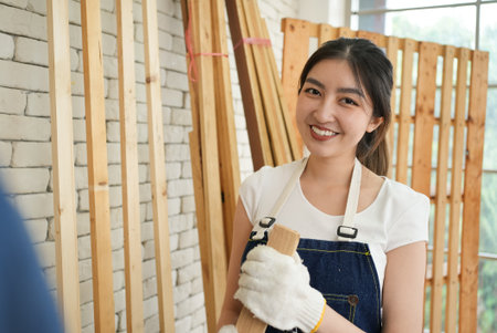 Portrait of happy carpenters designing and planing wood products in workshopの写真素材