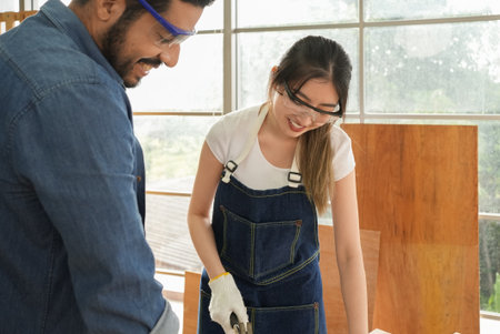 Female carpenter and male worker happy and making furniture in carpentry shopの写真素材