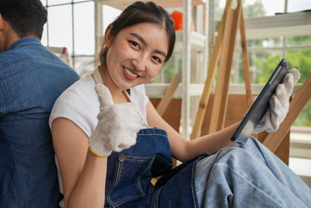 Portrait of happy carpenters designing and planing wood products in workshopの写真素材