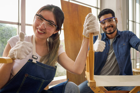 Portrait of professional female carpenter worker using electrical screwdriverの写真素材