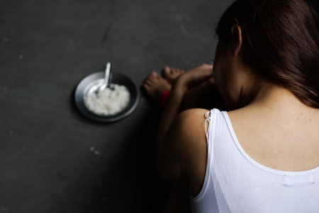 Victim of abducted woman bound wrists and feet in red ropeの写真素材