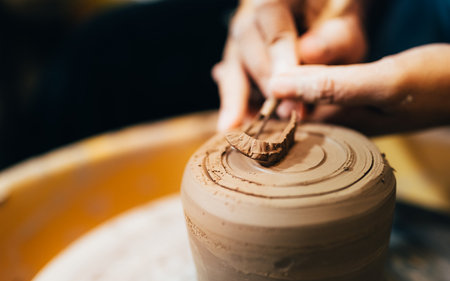 Craftsman potter making jug of clay on the potters wheel circle in workshopの写真素材