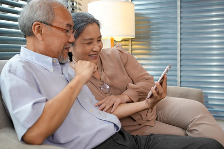 Couple of happy senior people smiling and spending time at homeの写真素材