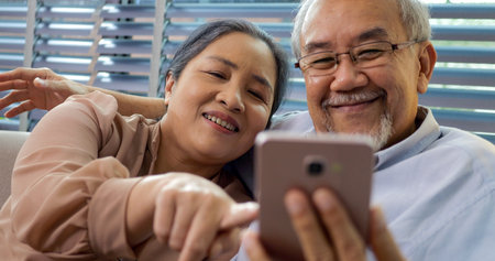 Couple of happy senior people smiling and spending time at homeの写真素材