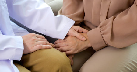 Close up hands of doctor touching female senior patient hands reassuring